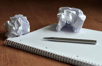 Wadded up paper ball on pad of paper